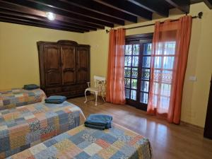 2 camas en una habitación con cortinas naranjas en Finca Los Loros Icod de los Vinos, en Santa Cruz de Tenerife