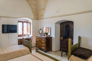 ラテルツァにあるSan Leonardo - ApartHotelのベッドルーム1室(ベッド2台、ドレッサー、テレビ付)