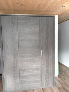 een grote metalen deur in een kamer met een houten plafond bij location studio vacances ou weekend Pra Loup résidence La Croix Haute in Uvernet