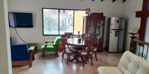 - un salon avec une table, des chaises et un réfrigérateur dans l'établissement Casa de recreo, à Santa Fe de Antioquia