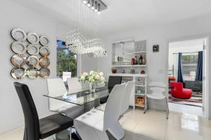 a dining room with a glass table and white chairs at 4 Br Heated Pool Hot Tub Lanai Outdoor Gazebo in Marco Island