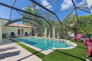 a swimming pool in a glass house with a patio at 4 Br Heated Pool Hot Tub Lanai Outdoor Gazebo in Marco Island