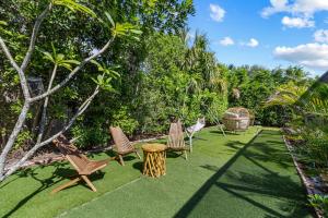 a yard with chairs and a table and trees at 4 Br Heated Pool Hot Tub Lanai Outdoor Gazebo in Marco Island