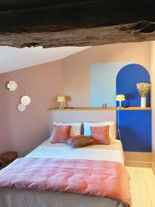una camera da letto con un grande letto con cuscini colorati di Maison d'hôte Les Allois a Limoges