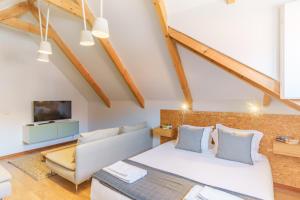 a bedroom with a bed and a couch and a tv at OX Apartments Taipas in Porto