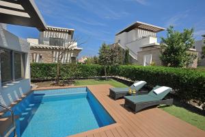 ein Garten mit Swimmingpool und ein Haus in der Unterkunft E-Hotel Larnaca Resort & Spa in Larnaka