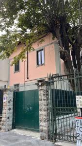 una casa rosa con una puerta verde y un árbol en FIERA Milano-City LIFE FREE PARKING Villa Anglia' s Bridge, en Milán
