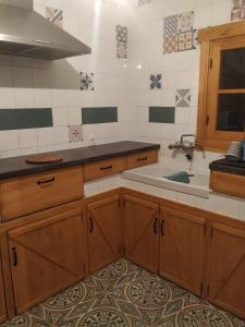 una cocina con armarios de madera y fregadero en Apartamento Trasiego, en Valdepeñas