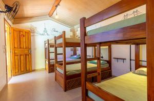 a room with three bunk beds in a house at Na Casa 11 - Pousada e Hostel in Arraial d'Ajuda