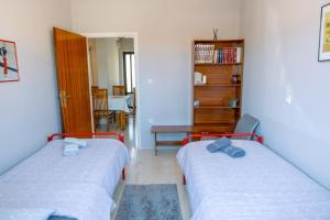a bedroom with two beds and a book shelf at Filoxenia House at Anemochori village in Pyrgos