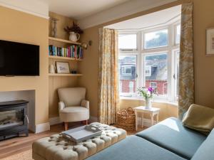 a living room with a blue bed and a fireplace at Cranford in Salcombe