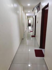 a hallway with white walls and a long corridor at ZMK STAY 