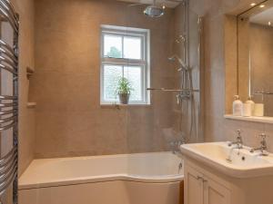 a bathroom with a shower and a tub and a sink at Cranford in Salcombe