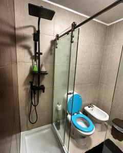 y baño con aseo azul y ducha. en Private Bedroom with Balcony & Private Bathroom in Modern Shared Apartment - King & Queen size bed, en Vila Nova de Gaia