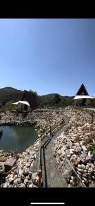 a river with rocks and houses in the background at Bungalow Gölçam in Denizli