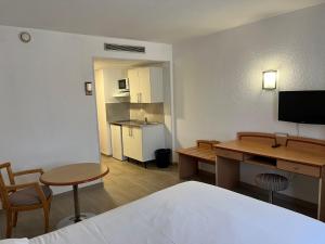 um quarto de hotel com uma cama, uma secretária e uma cozinha em RESID'ARTEL em Fos-sur-Mer
