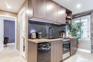 a kitchen with a sink and a stove at Beautiful Vieux 2 Bedroom Apt in Quebec City