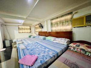a bedroom with two twin beds and a pink pillow at King Henry's Transient House in Bantay