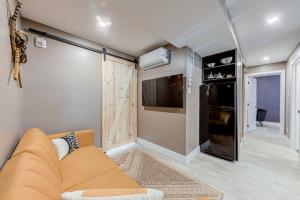 ein Wohnzimmer mit einem Sofa und einem TV in der Unterkunft Beautiful Vieux 2 Bedroom Apt in Québec