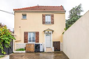 a house with a white door and a microwave at Location Cosy Paris in Saint-Michel-sur-Orge