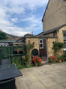 a brick house with flowers in a courtyard at Flat 2 The Butlers Quarters in Oswestry