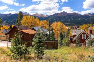 Una casa con una valla y montañas al fondo. en Ravens Call Chalet, en Breckenridge