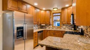 Una cocina con gabinetes de madera y un refrigerador de acero inoxidable. en Ravens Call Chalet, en Breckenridge