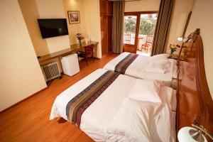 a hotel room with a large bed with a television at Hotel Agustos Urubamba in Urubamba