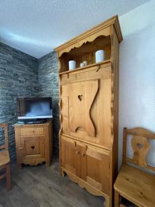 a large wooden cabinet in a room with a television at Superbe studio au pied des oeufs in Champagny-en-Vanoise