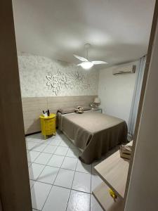 a bedroom with a bed and a yellow table at Apartamento Areia Preta Guarapari in Guarapari