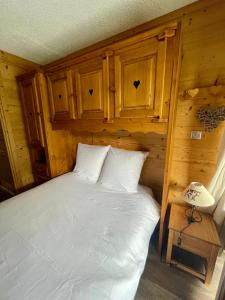 a bedroom with a white bed in a cabin at Superbe studio au pied des oeufs in Champagny-en-Vanoise