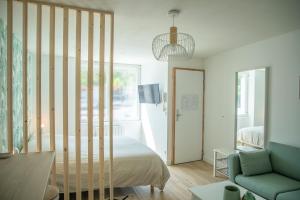 a bedroom with a bed and a living room with a couch at Le Jade - Appart'Escale in Saint-Nazaire