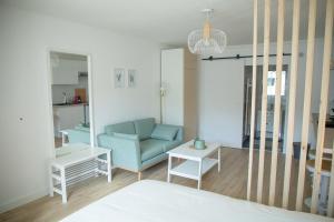 聖納澤爾的住宿－Le Jade - Appart'Escale，客厅配有蓝色的沙发和桌子