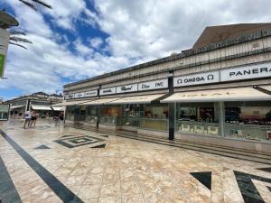 a building with people walking in front of it at 5 min walk to Gold Mile and 7min to best Las Americas Beach WiFi in Arona