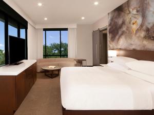 Delta Hotels by Marriott Dallas Southlake في ساوثليك: غرفة نوم بسرير ابيض كبير وغرفة معيشة