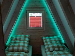 een kamer met 2 bedden en een raam op een zolder bij Hütte 19 in Freyung