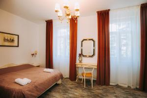 a bedroom with a bed and a desk and a mirror at Conacul Buzdugan 