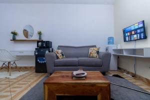 - un salon avec un canapé et une table dans l'établissement Kilifornia Comfy Studio, à Kilifi