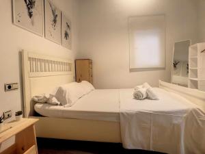 a bedroom with a white bed with towels on it at Apartamento centro de malaga in Málaga