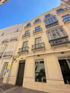 a large tan building with windows and balconies at Apartamento centro de malaga in Málaga