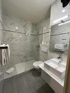 パリにあるオテル ベルフォールのバスルーム(トイレ、洗面台、シャワー付)