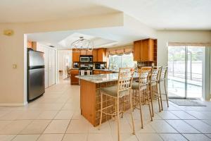 a kitchen with a large island with bar stools at Marco Island Retreat with Pool about 1 Mi to Beach in Marco Island