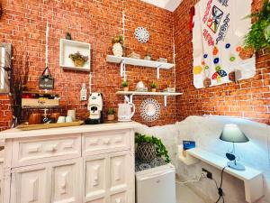 een keuken met een bakstenen muur en een aanrecht met een lamp bij Regina Elena in Cinisi
