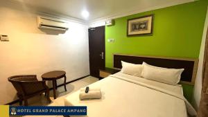 a hotel room with a bed and a green wall at Hotel Grand Palace Ampang in Ampang