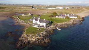 a house on an island in the water at Hen Cymyran in Caeʼr-geiliog