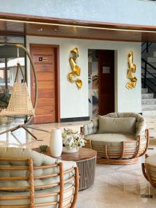 ein Wohnzimmer mit Stühlen und einem Tisch in der Unterkunft Principe do Mutá Hotel Design in Santa Cruz Cabrália