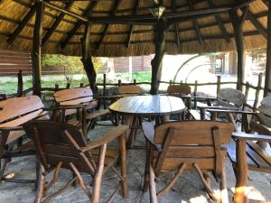 un grupo de mesas y sillas bajo una cabaña en Гута Вікенд, en Guta