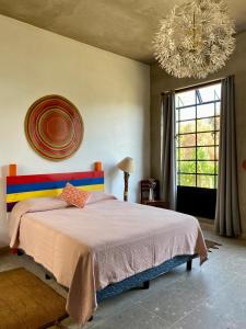Un dormitorio con una cama grande y una lámpara de araña. en Casa Flora 32, en Mixquiahuala 12 fotos más