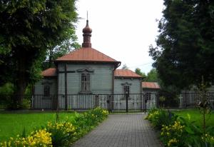 una vecchia casa con una recinzione in un parco di Domek Roztocze a AdamÃ³w