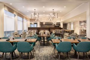 Hilton Garden Inn Houston Energy Corridor في هيوستن: غرفة طعام مع طاولات وكراسي